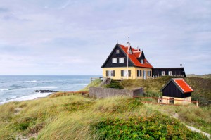 Ein dänisches Haus auf einer Anhöhe nahe eines Strandes.